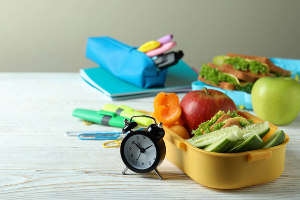 Study concept with lunch boxes on white wooden table - Фото, изображение