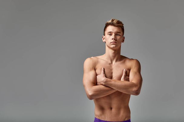Young swimmer in excellent physical shape, on a gray background with copy space, call for sports, advertising banner - Foto, immagini
