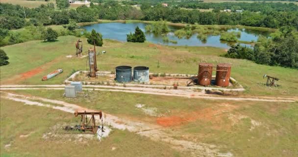 Un puits de pétrole pompe Jack pompage du pétrole brut un de l'Oklahoma une journée ensoleillée - Séquence, vidéo