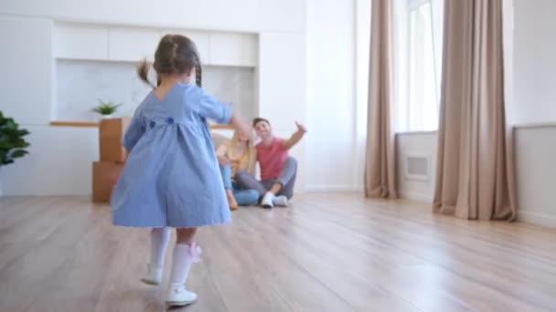 Joyeux enfant d'âge préscolaire avec des tresses court aux parents et câlins - Séquence, vidéo