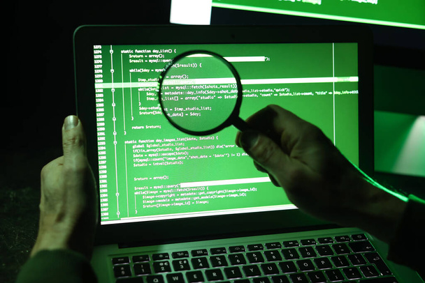 Hacker nagyítóval számítógéppel - Fotó, kép