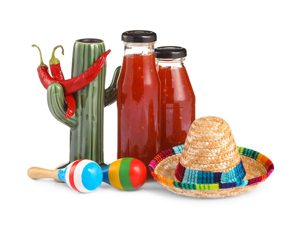 Flessen chili saus met symbolen van Mexico op witte achtergrond - Foto, afbeelding