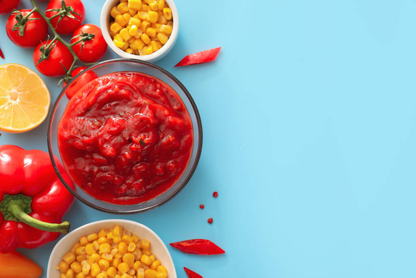 Bowl of tasty salsa sauce with products on color background - Fotografie, Obrázek