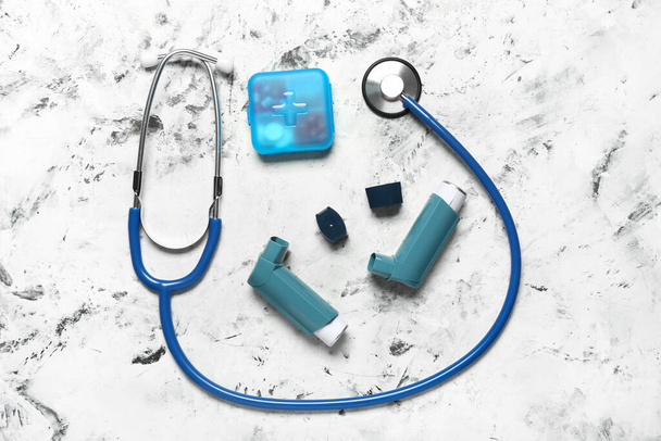 Modern inhalers, pills and stethoscope on grunge background - Foto, imagen