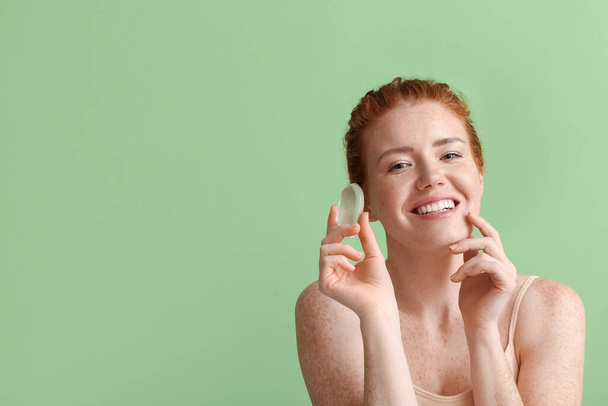 Красивая молодая женщина с губкой для макияжа на цветном фоне - Фото, изображение