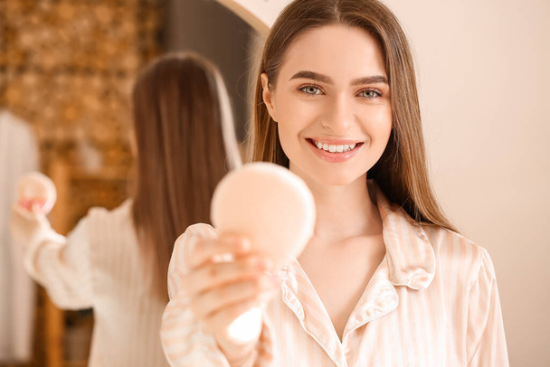 Mooie jonge vrouw aanbrengen van make-up in de badkamer - Foto, afbeelding