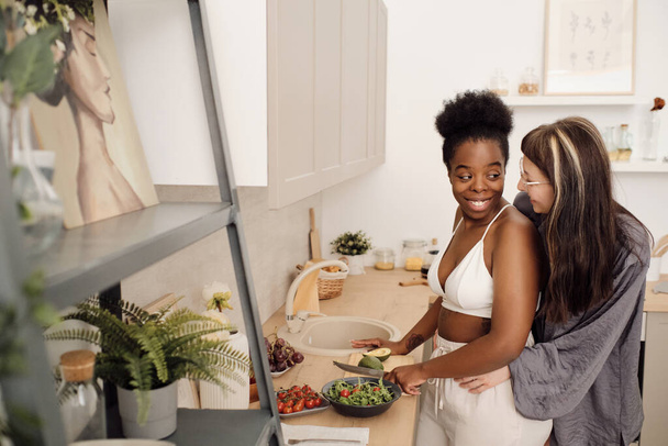 Two happy young girlfriends cooking breakfast - Photo, Image