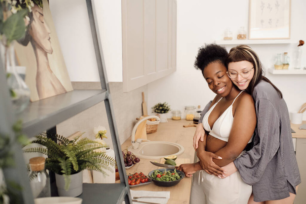 Kaksi iloinen naaraat ruoanlaitto salaatti yhdessä keittiössä - Valokuva, kuva