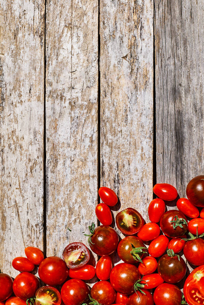 Červená zralá rajčata textury pozadí. Různé vlastnosti rajčat na dřevěném stole. Černé rajče Solanum lycopersicum. - Fotografie, Obrázek