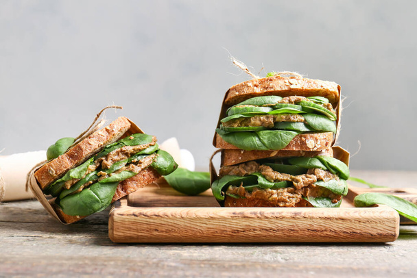 Deska s chutnými sendviče na světle dřevěném pozadí - Fotografie, Obrázek