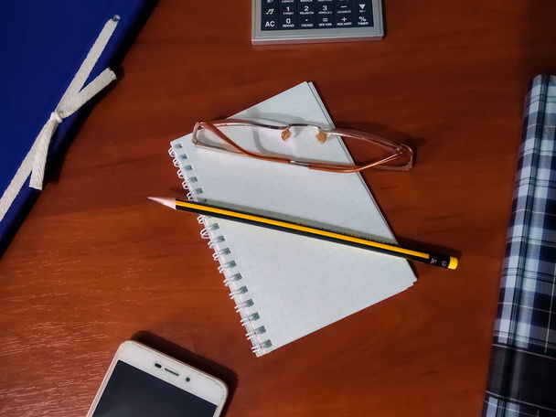 Notebook, tervezés és szervezés, ceruza, szemüveg, számológép, mappa papírok, okostelefon - Fotó, kép