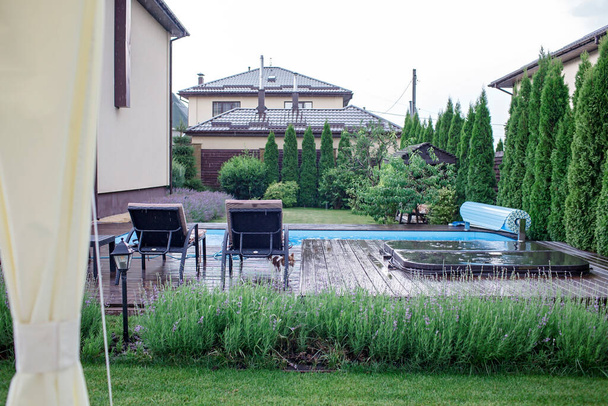 Wellnessbereich im Hinterhof des Hauses im Sommer, Schwimmbad, helle bunte weichen Stuhl, frohe Ferien - Foto, Bild