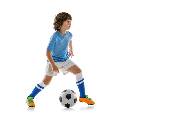 Young sportsman, football soccer player, child playing football isolated on white studio background. Concept of sport, game, hobby - Фото, зображення