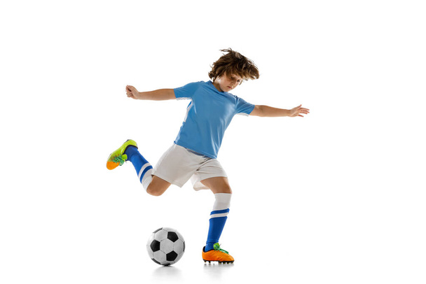 Portrait of preschool boy, football soccer player in action, motion training isolated on white studio background. Concept of sport, game, hobby - Фото, изображение