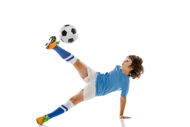 Young sportsman, football soccer player, child playing football isolated on white studio background. Concept of sport, game, hobby - Foto, imagen