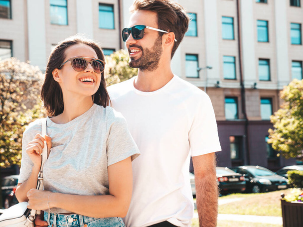Portrait of smiling beautiful woman and her handsome boyfriend. Woman in casual summer clothes. Happy cheerful family. Female having fun. Couple posing on the street background in sunglasses - Foto, Bild