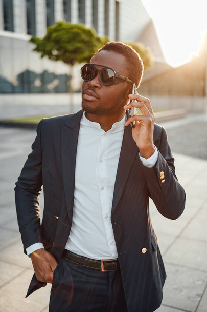 Прохолодний бізнесмен африканського походження з телефоном
 - Фото, зображення