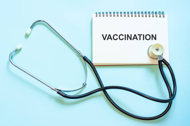 Vaccinazione - su un blocco note, come una raccomandazione. Blocco note del medico accanto a uno stetoscopio su uno sfondo di betulla - Foto, immagini