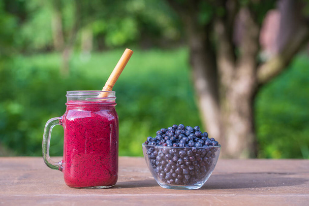 Delicious blueberry smoothie in a glass mug on the table, close up - Фото, зображення