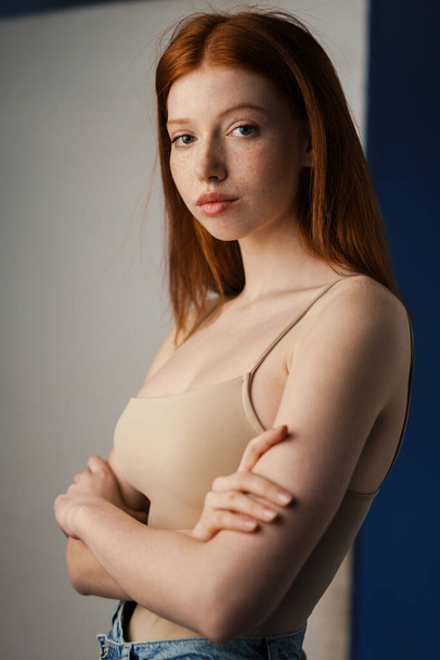 Close up of a young red haired woman posing indoors, looking at camera - Valokuva, kuva