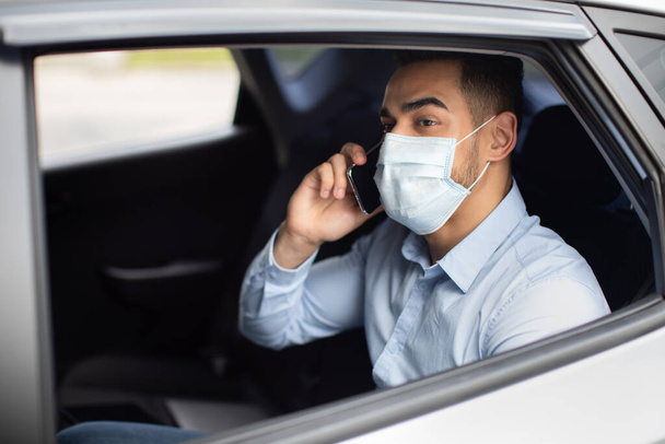 Closeup of arab businessman in face mask sitting in car - Photo, Image