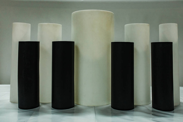 black cylindrical plastic pipes of different diameters are in stock. exhibition samples of the products of the pipe rolling plant. polymer pipes for laying underground utilities - Foto, Imagem