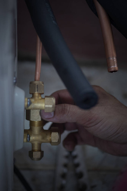 Imagem do técnico de ar condicionado está conectando tubos para trazer condicionadores de ar para casa., equipamento de ar condicionado. - Foto, Imagem