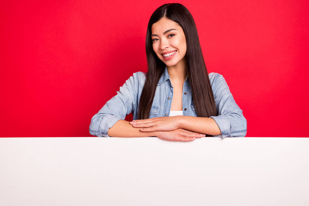 Portrait of pretty cheerful girl holding big board desk promo promotion gift present isolated over bright red color background - Fotografie, Obrázek