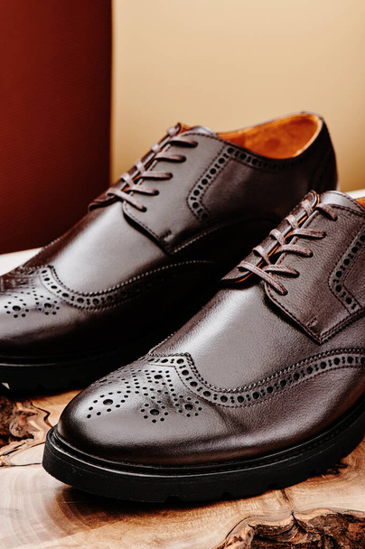Brown leather mens shoes in classic style on a wooden cut. Close-up - Photo, Image