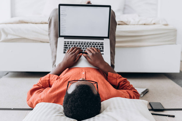 Nero giovane blogger lavora su laptop con schermo bianco - Foto, immagini