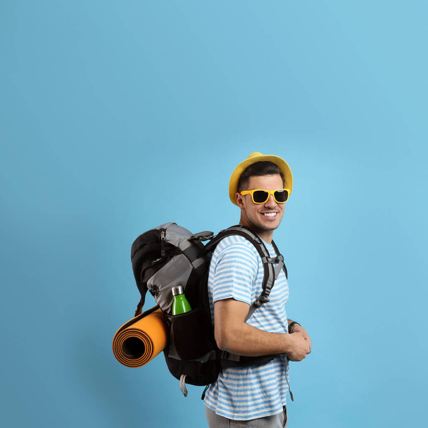 Male tourist with travel backpack on turquoise background, space for text - Fotoğraf, Görsel