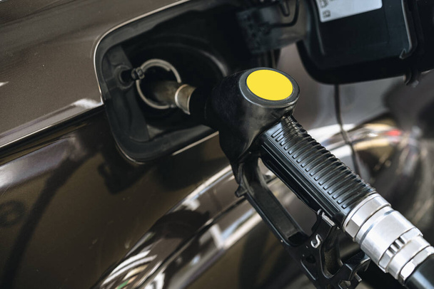 Pumping gasoline fuel in brown car at gas station - Zdjęcie, obraz