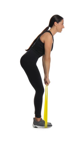 Woman doing sportive exercise with fitness elastic band on white background - Fotó, kép