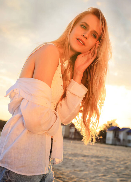 Beautiful young woman on beach at sunset - Foto, Bild