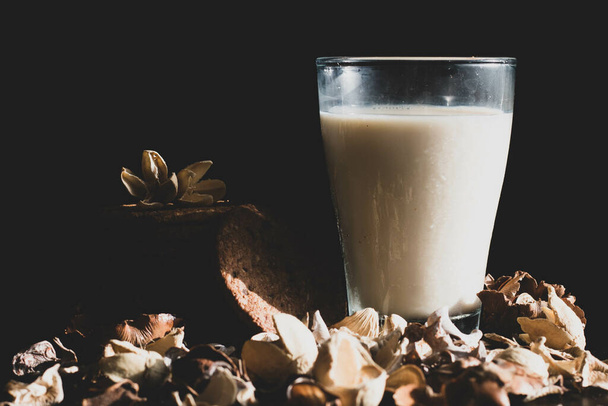 A glass of oat milk and cookies on a black background - Zdjęcie, obraz