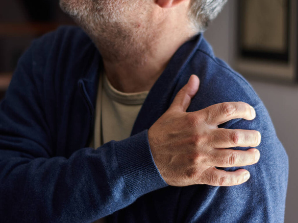 A closeup shot of a middle-aged Caucasian male with osteoarthritis pain - Fotó, kép