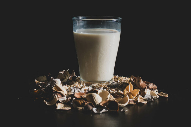 A glass of oat milk on a black background - Fotoğraf, Görsel