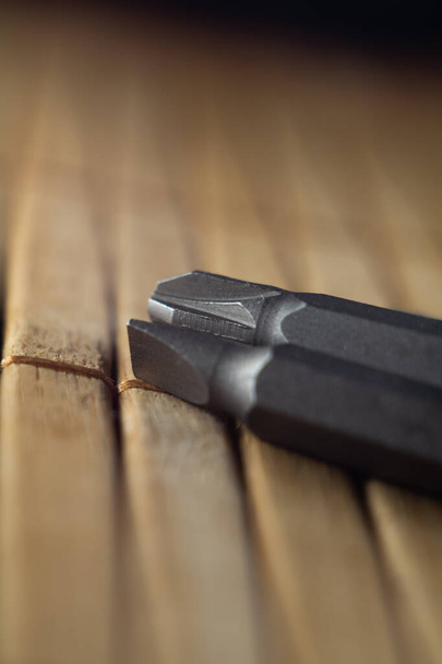 A vertical closeup shot of different sizes of screwdrivers on a wooden surface - Φωτογραφία, εικόνα