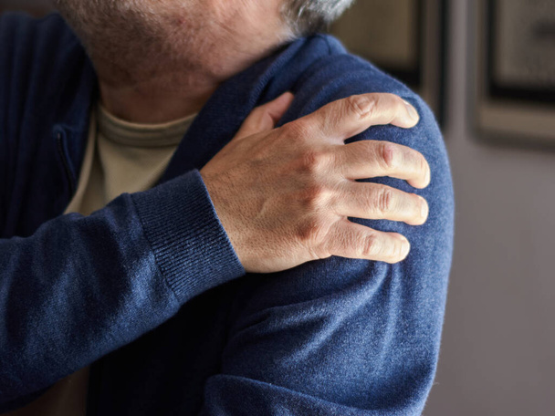 Un primer plano de un varón caucásico de mediana edad con dolor de osteoartritis - Foto, imagen