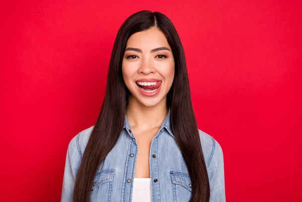 Photo of young attractive asian girl happy positive smile lick tongue teeth yummy dessert isolated over red color background - Fotografie, Obrázek