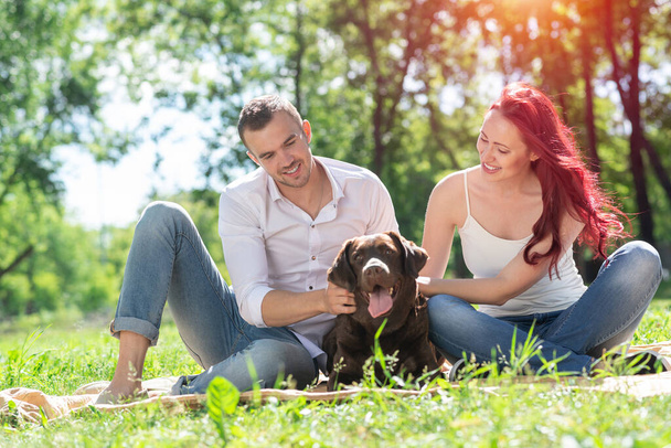 Couple with a dog in the park - Foto, imagen
