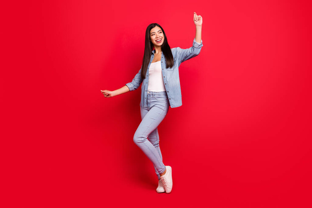 Full length body size view of attractive cheerful carefree girl having fun dancing isolated over bright red color background - 写真・画像