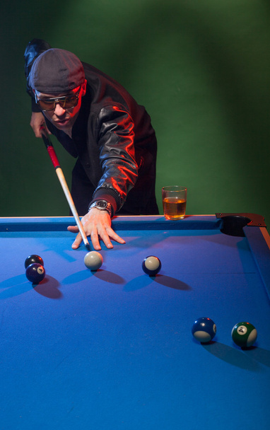 Trendy dude playing a game of pool in a nightclub - Photo, Image