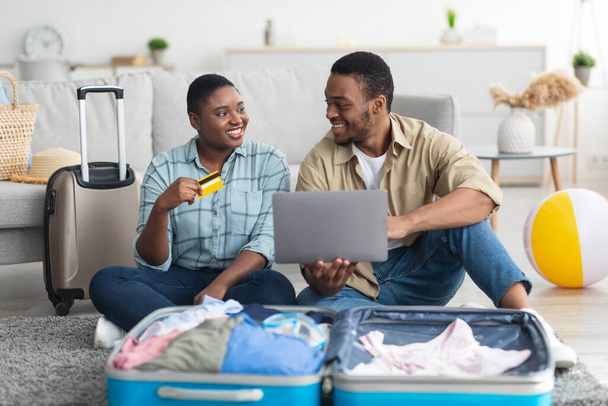 Schwarzes Paar mit Laptop und Kreditkarte buchen Urlaub im Haus - Foto, Bild