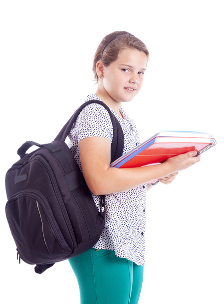Portrait of a smiling school girl with backpack holding notebook - Foto, imagen