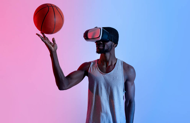 Millennial musta koripalloilija pelaa palloa virtuaalitodellisuus kuulokkeet, neon valaistus - Valokuva, kuva