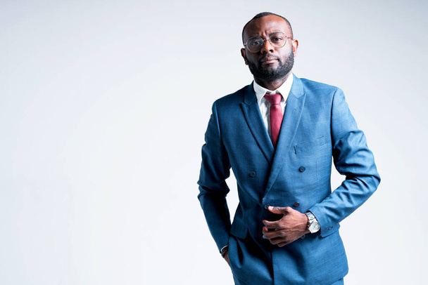 Serious african businessman in a suit wearing glasses and with a black beard looking at the camera - Photo, image