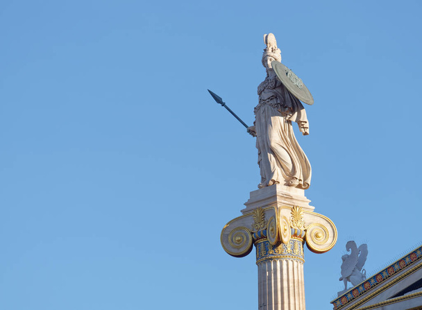 Athena e piccola statua della sfinge sotto lo sfondo del cielo blu, spazio per il testo - Foto, immagini