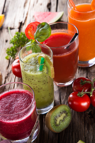 Fresh fruit juices on wooden table - Fotó, kép