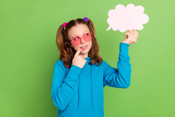 Photo of minded young thoughtful girl look hold hand cloud bubble minded isolated on green color background - Foto, Bild
